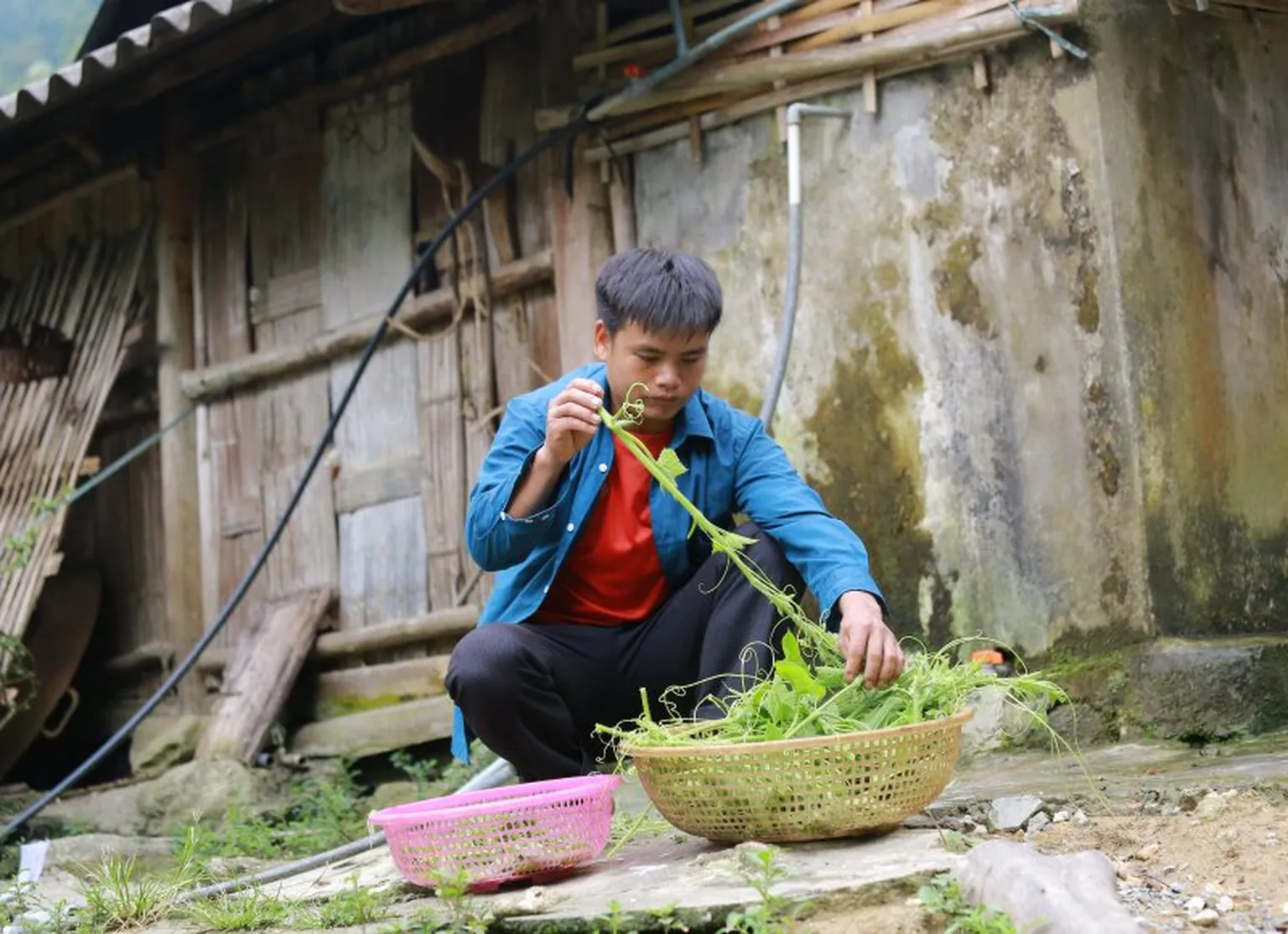 Ly A Sieu is cooking while his wife is attending a social event in the commune