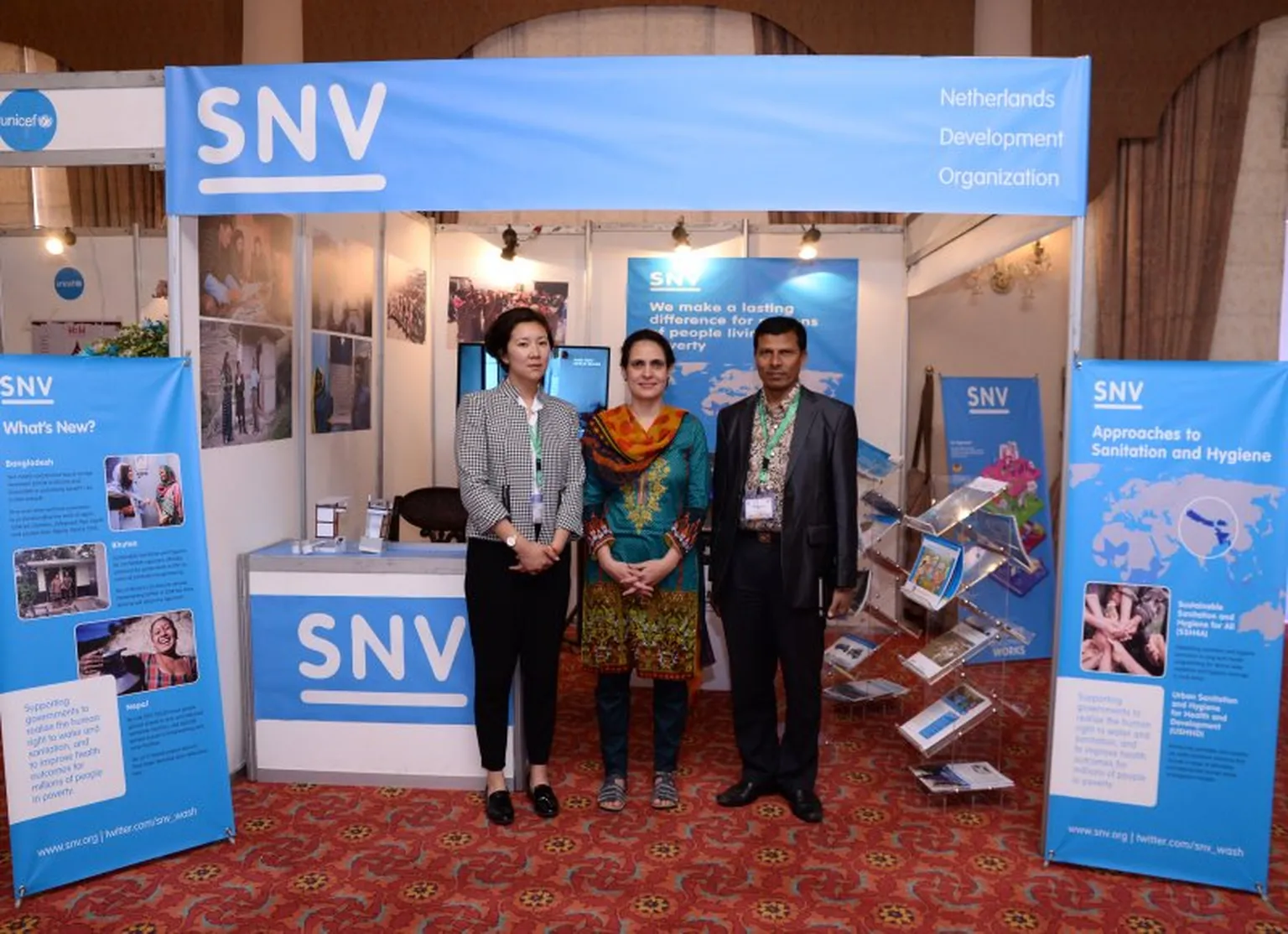 SNV colleagues in South Asia proudly stand in front of the SNV booth