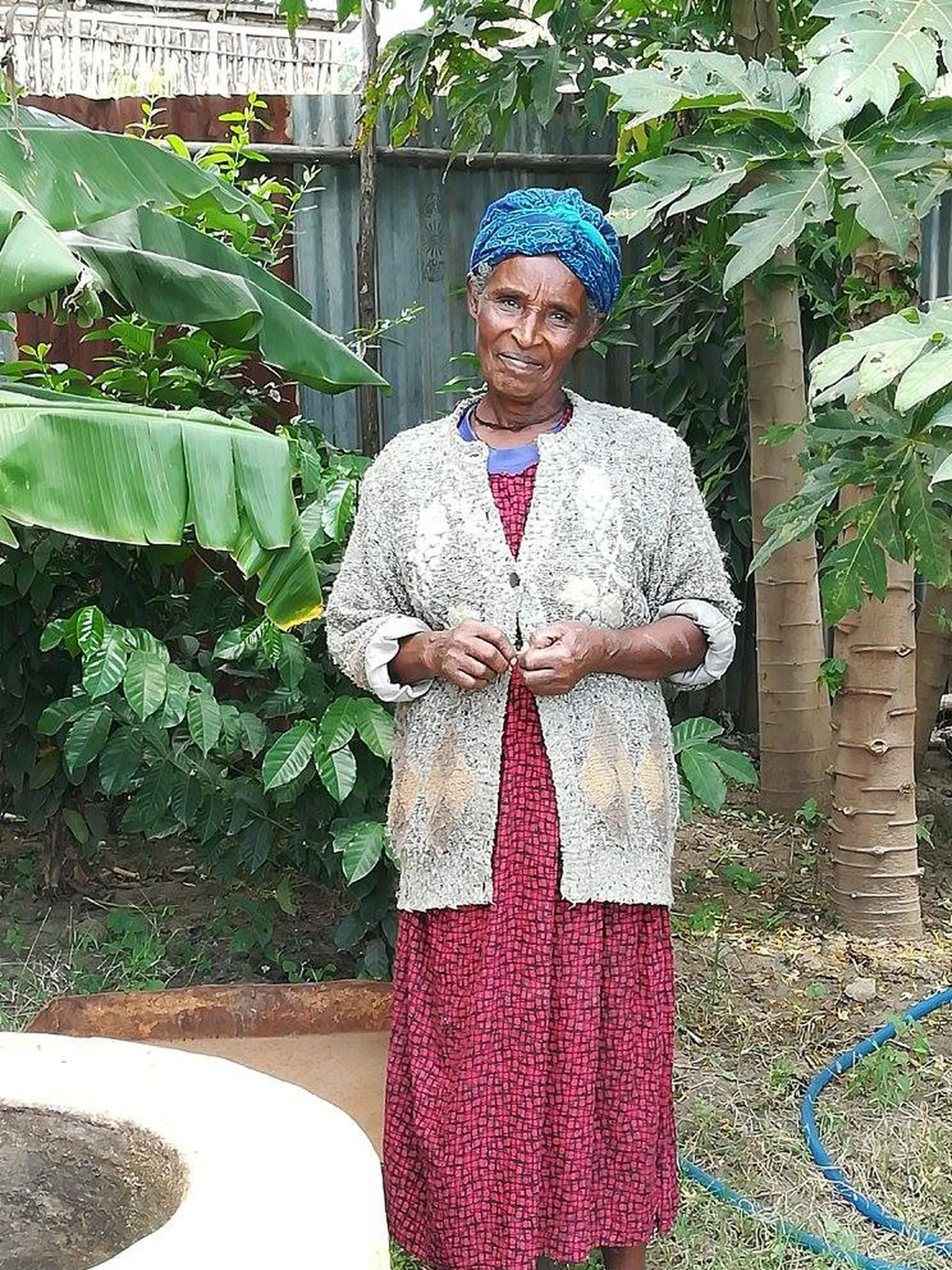 A woman standing beside a household bio-digester 