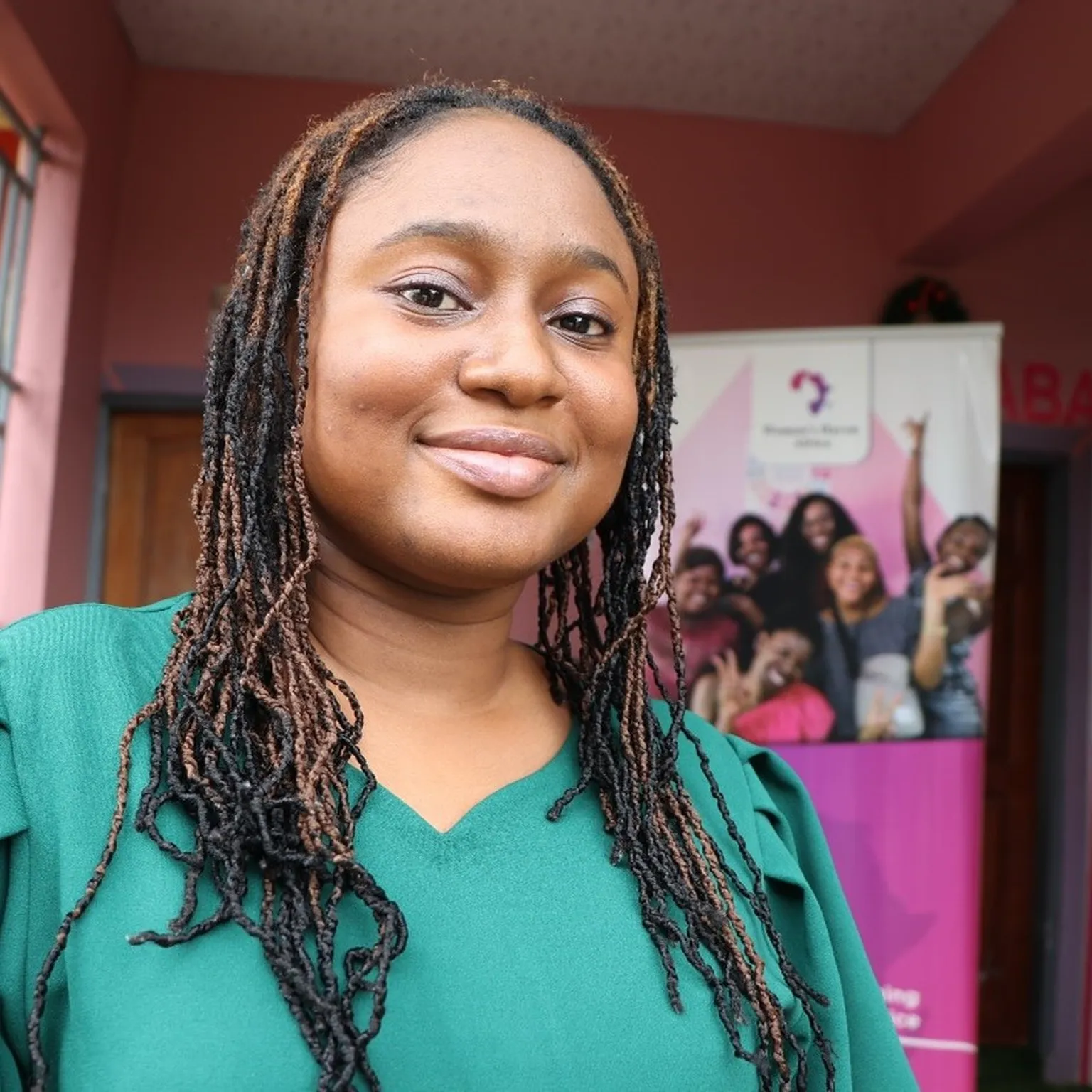Adwoa stands in front of the entrance of the Women’s Haven Africa office