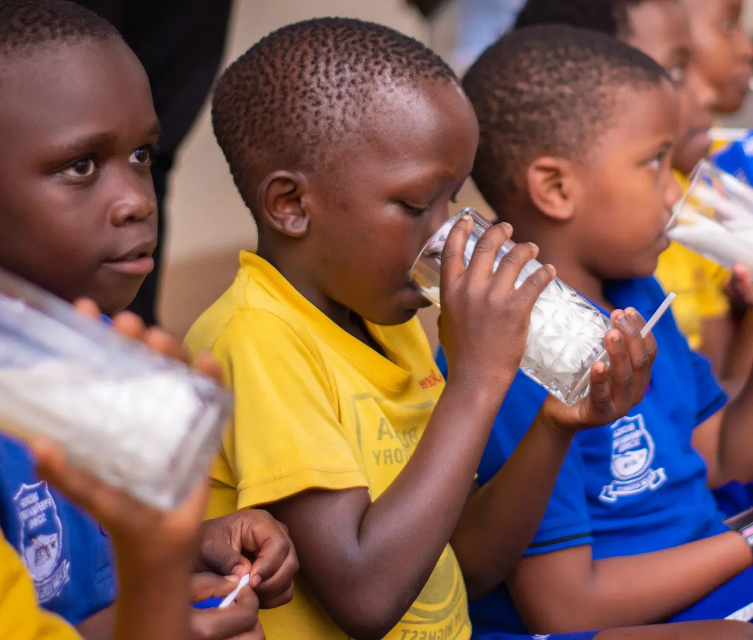Children drink milk in a school in Kampala, Uganda, as part of SNV TIDE project