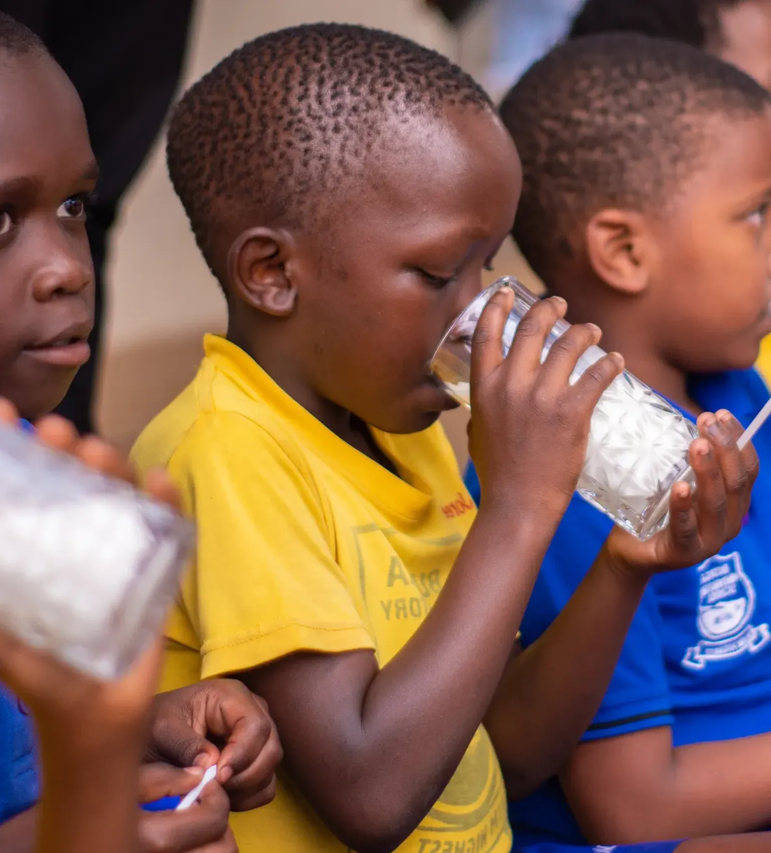 Children drink milk in a school in Kampala, Uganda, as part of SNV TIDE project