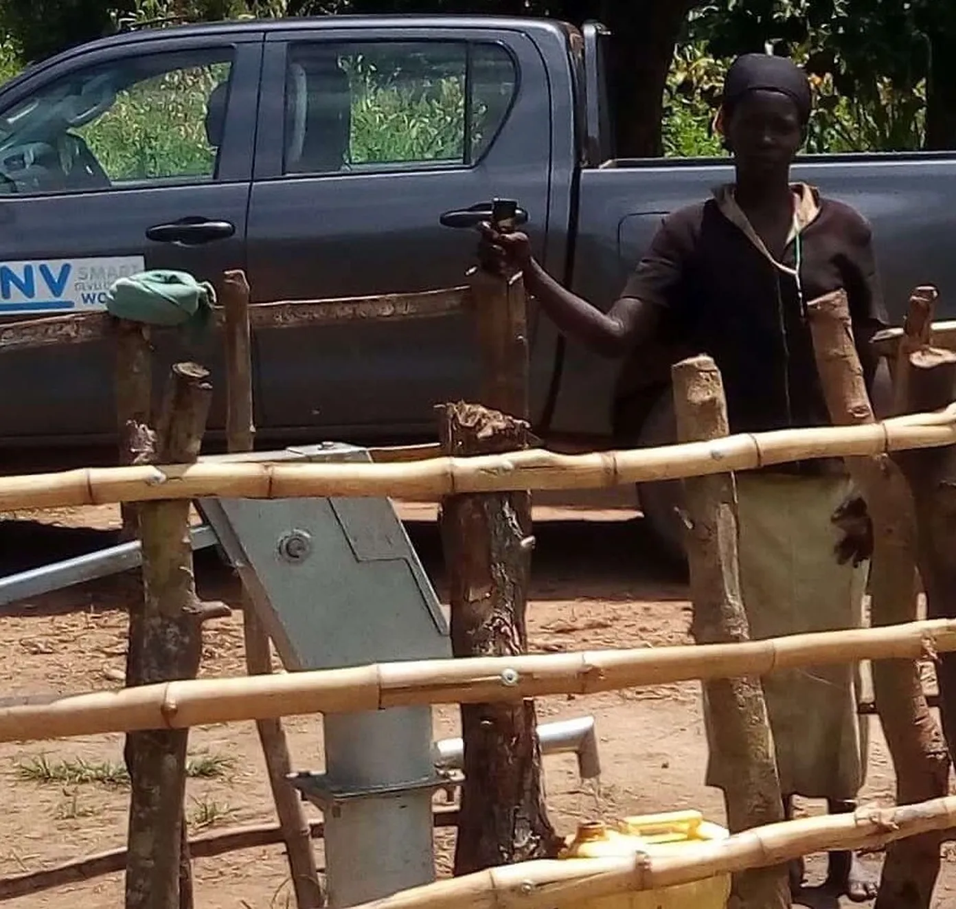 Female Caretaker inspects water source 
