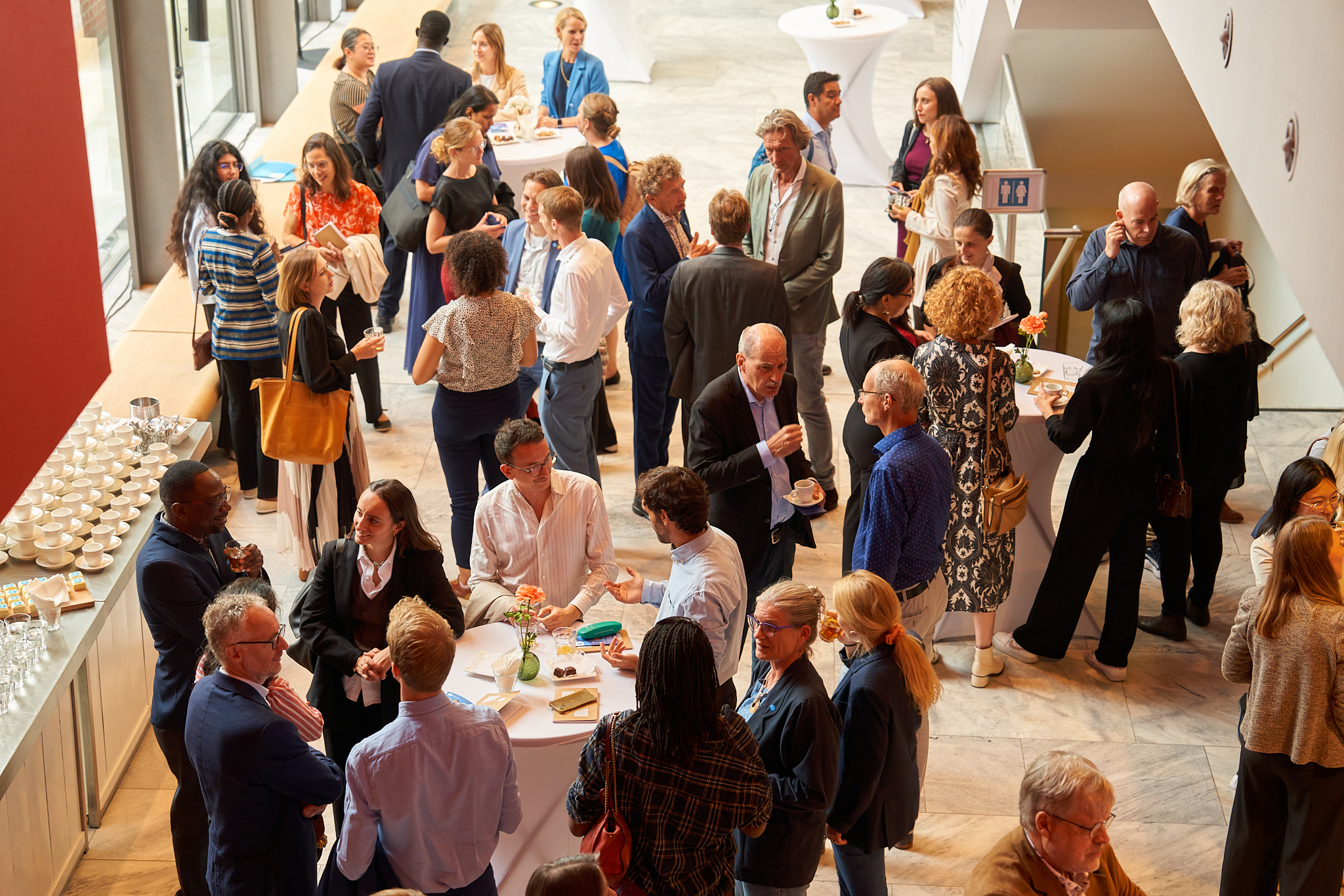 Attendees of the SNV60 event speaking to each other