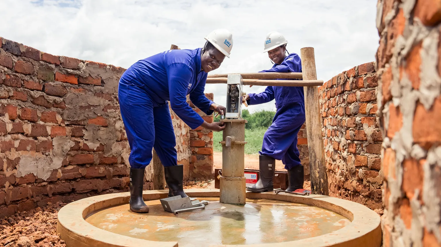 Women hand pump mechanics fixing a borehole