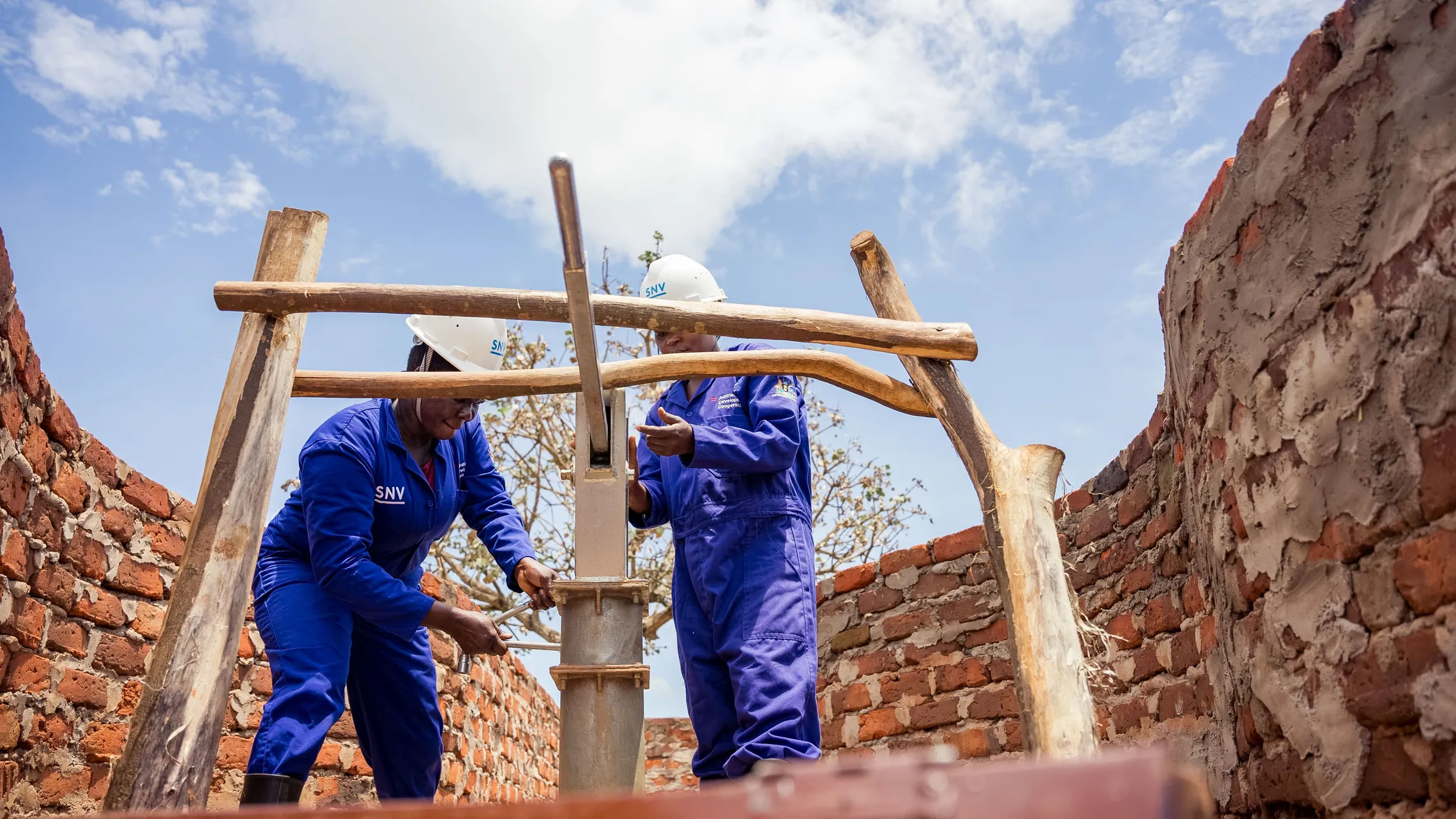 Women hand pump mechanics fixing a borehole