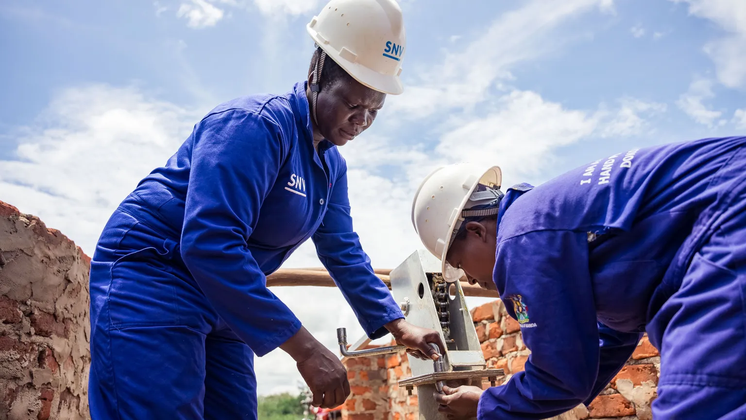 Women hand pump mechanics fixing a borehole