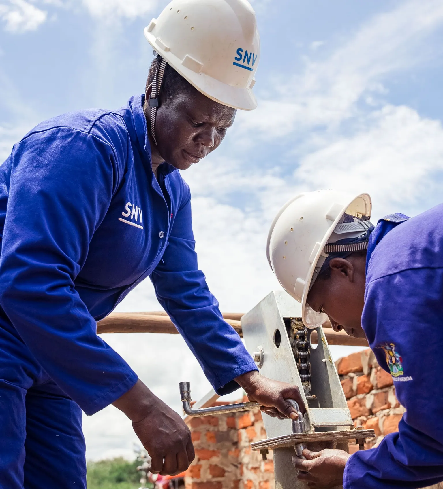 Women hand pump mechanics fixing a borehole