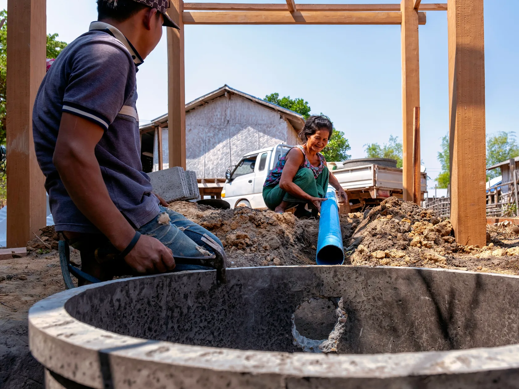 Household toilet client in Lao PDR watches the installation of our her toilet closely.