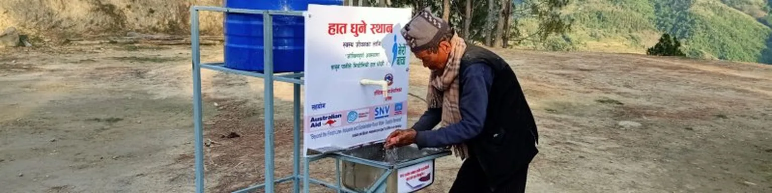 Man washing hands at a station.