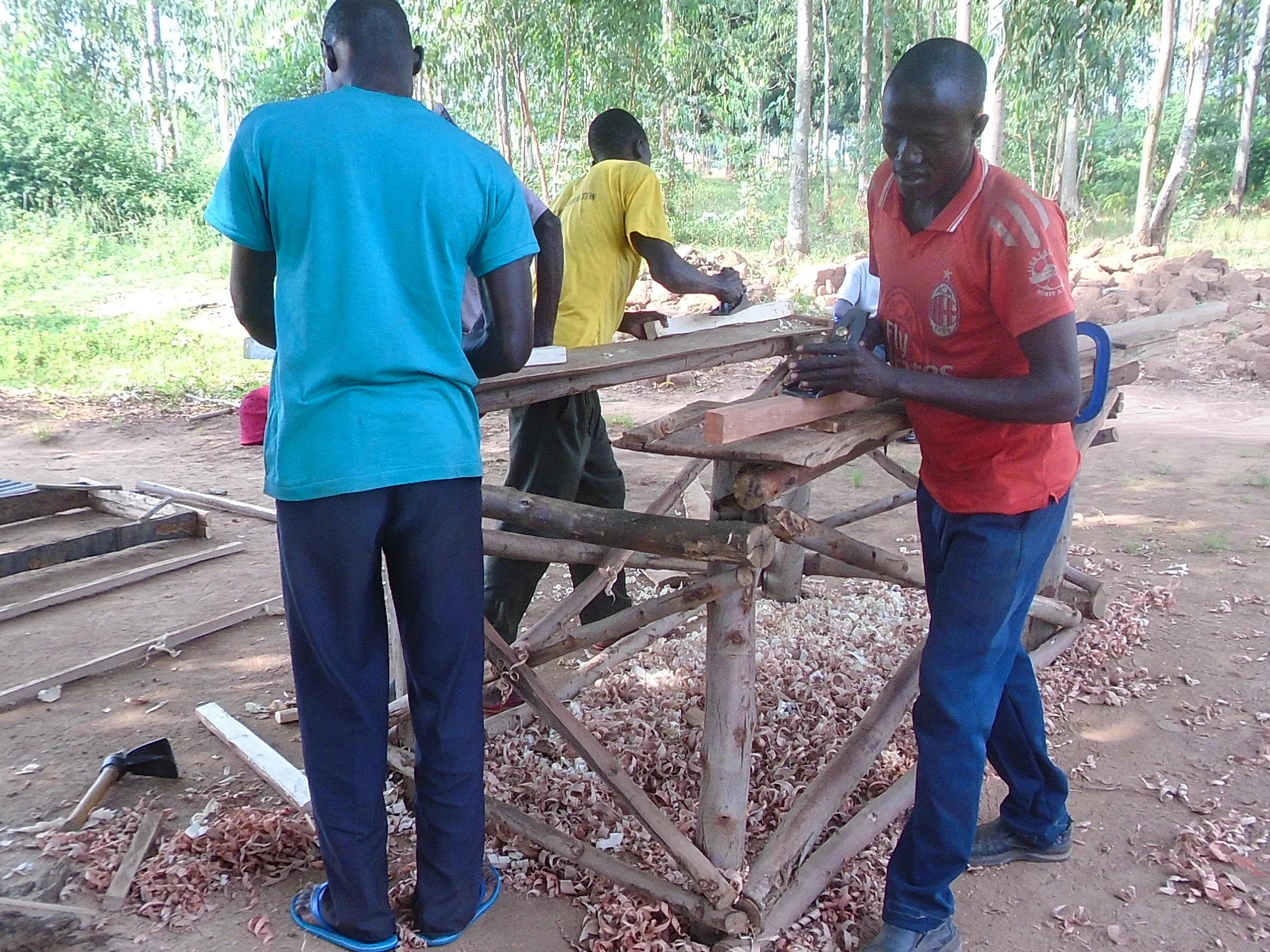 Cosmas (in red T-shirt) opened a carpentry workshop