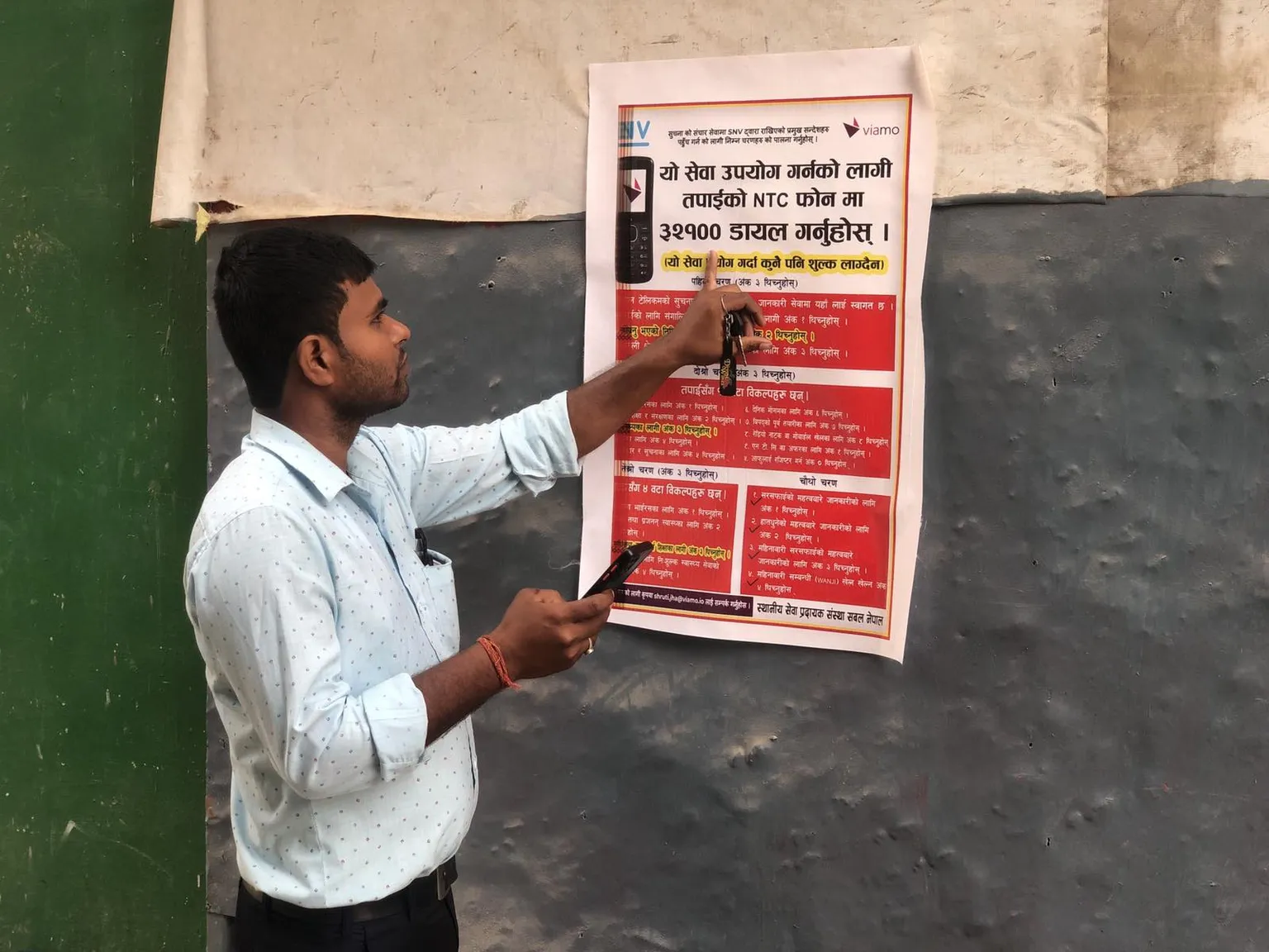 Poster in Saptari Nepal pointing residents into the direction of digital information platforms for COVID and MHH advice (Photo: Parmeshwar Jha, Sabal Nepal)