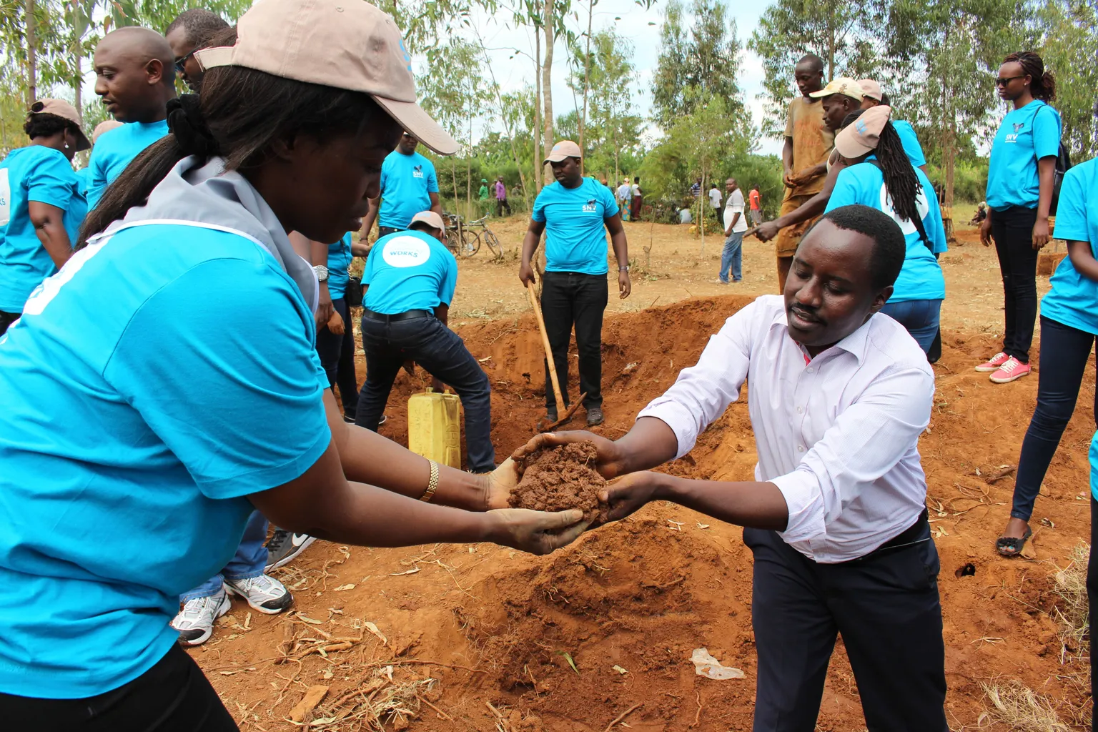 Teamwork:SNV staff and district mayor scoop mud to lay bricks to build latrines