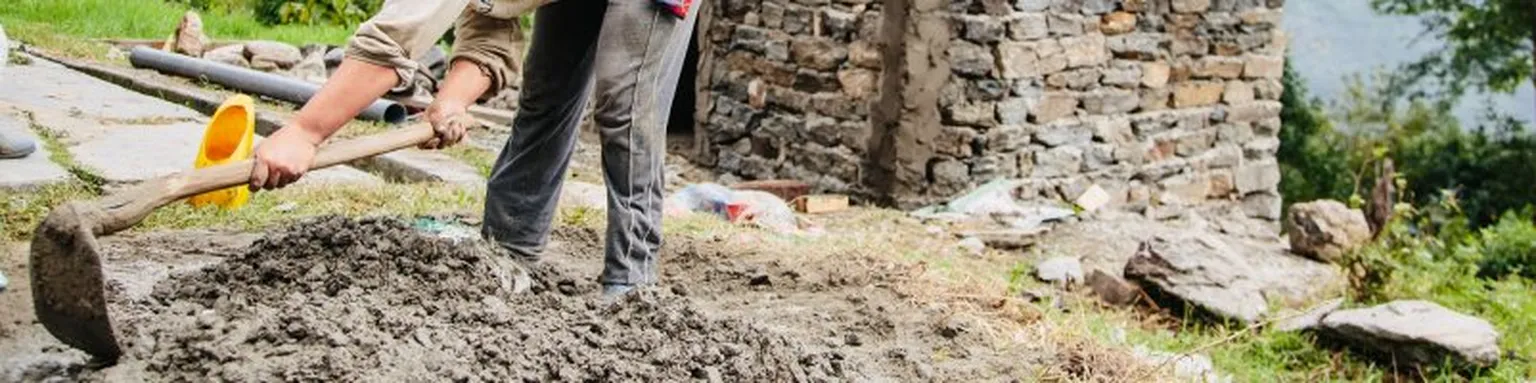 Person digging with a hoe.