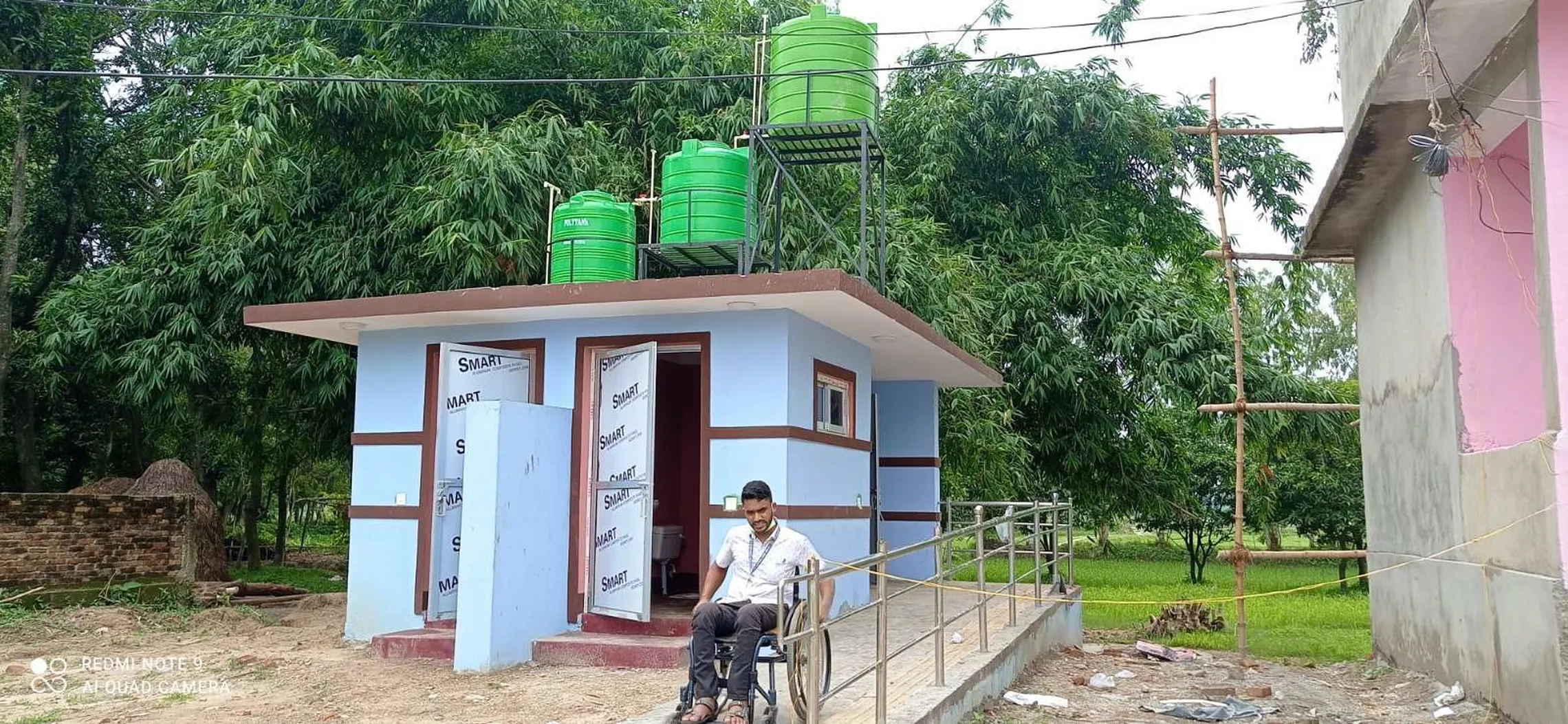 Ajay Shah, focal person for HCF in front of a disability friendly toilet in Parsa