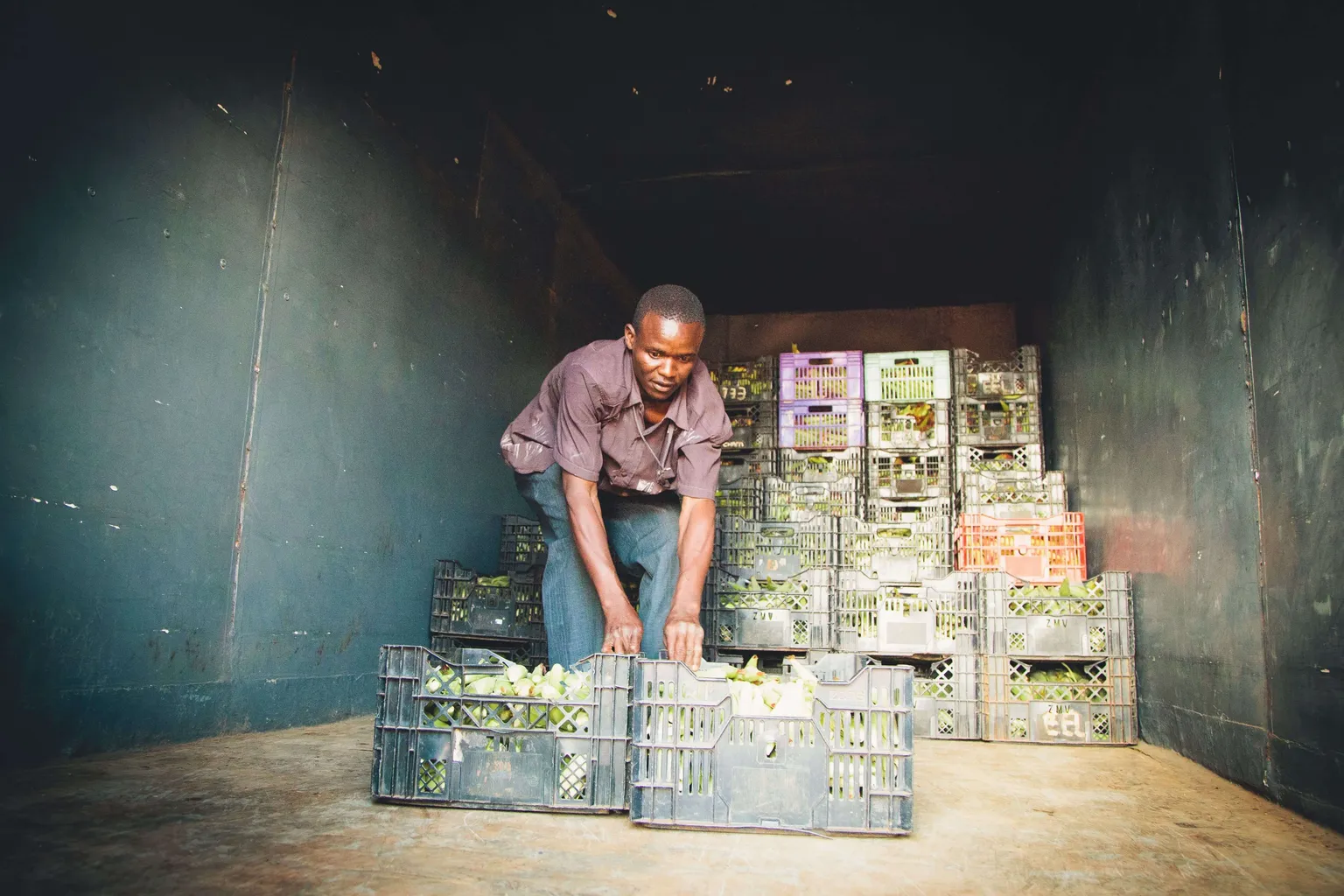 man loading vegetables onto a truck 