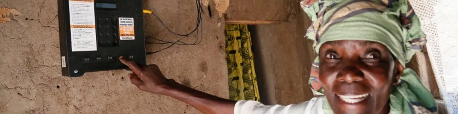 Lady pointing at an electrometer.