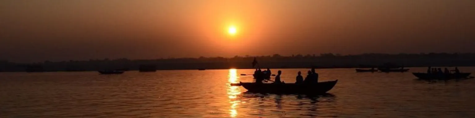 People in a boat at sunset.