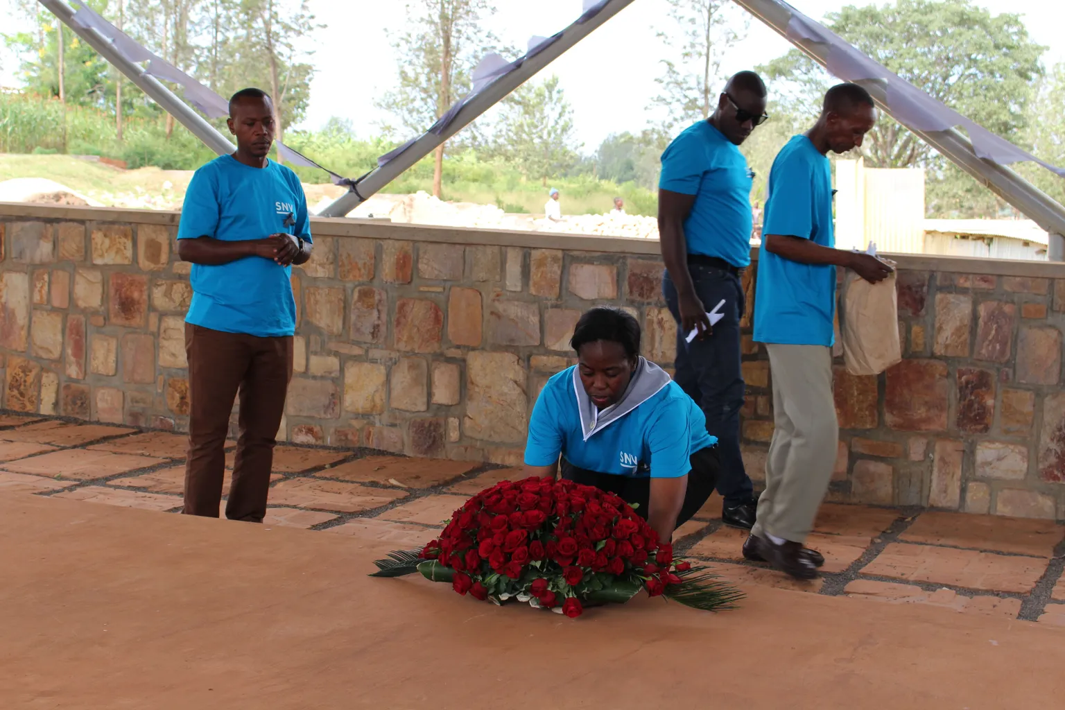 Country Director Phomolo Maphosa places a wreath on one of the mass graves
