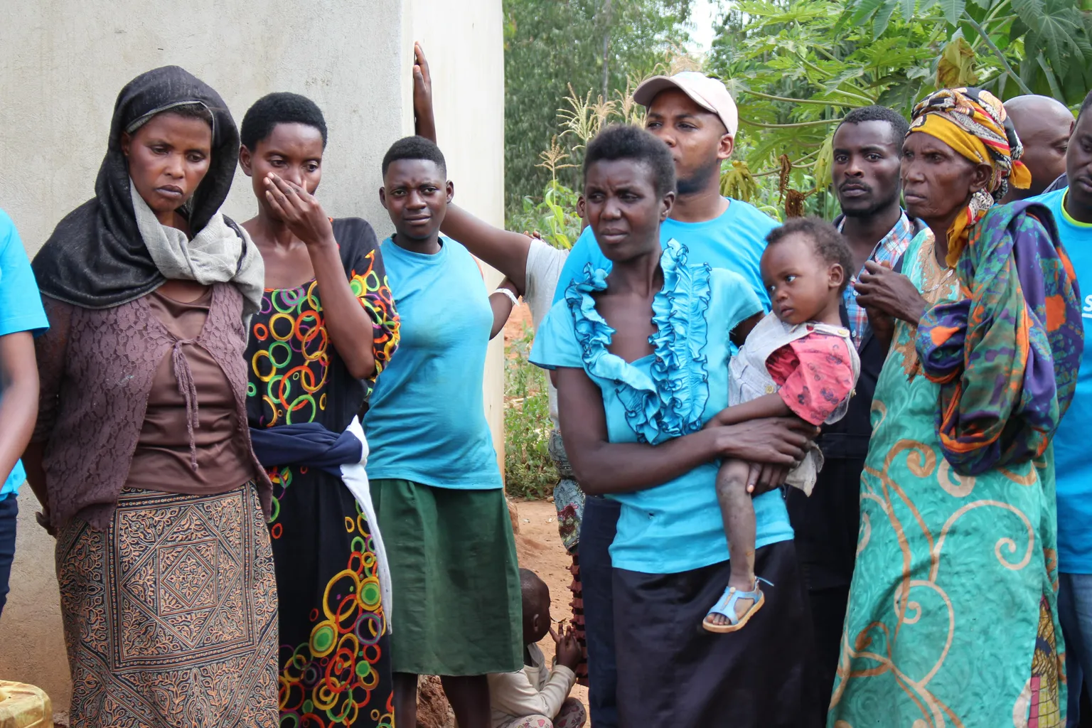 Helena Nyirasafari, (left) and fellow genocide survivors listen to speeches 