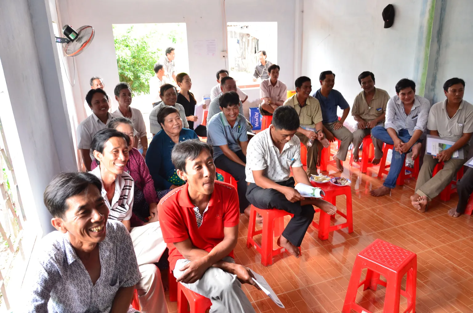A group of people sitting on the chairs, listening and smiling