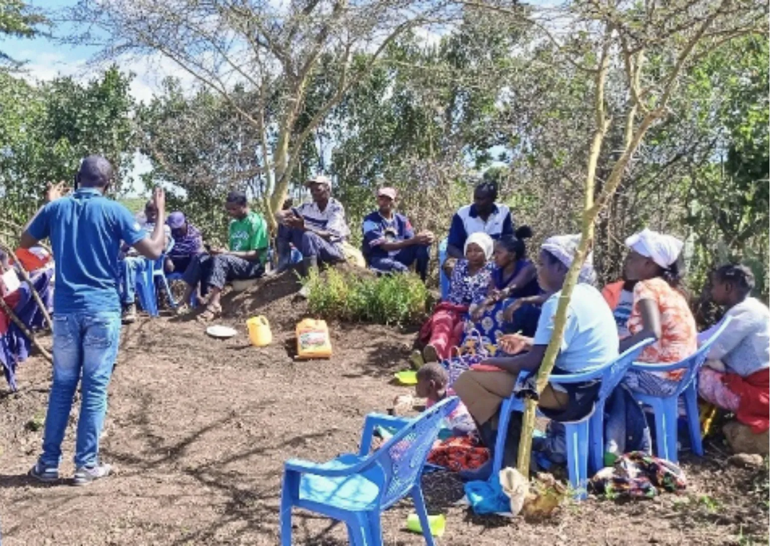 A group of farmers sit in a circle outside 